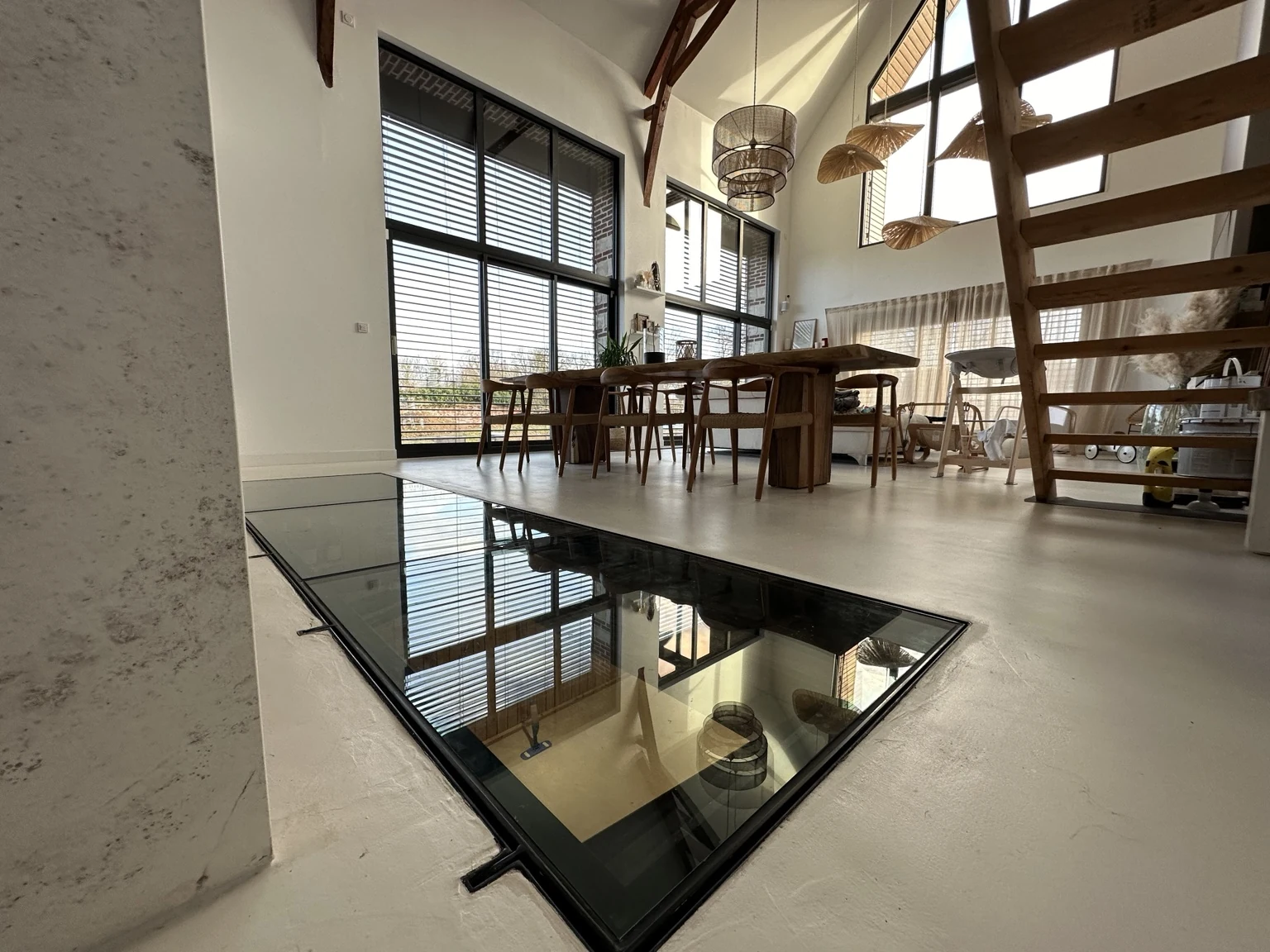 Trappe de cave vitrée affleurante dans le sol d’une salle à manger — réalisation Art et Fer